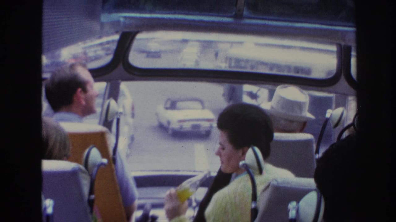 1967 Paris travel footage looking through a tour vehicle interior toward street traffic and seated passengers.