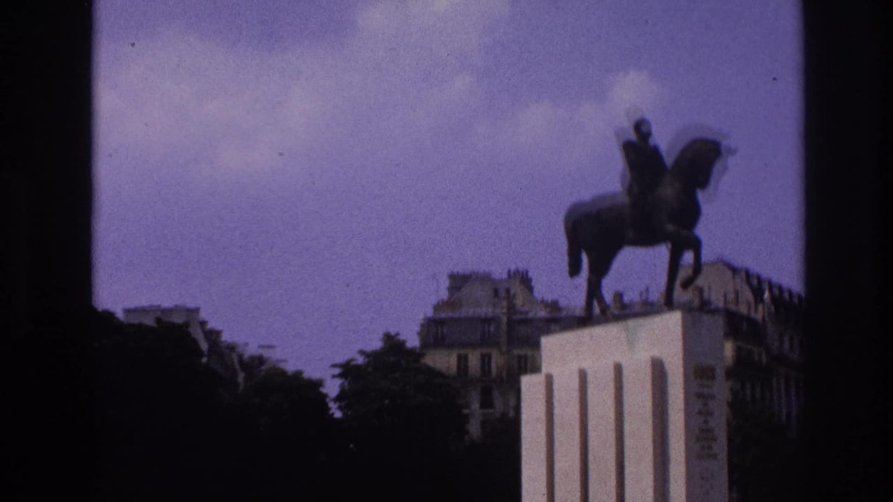 Equestrian statue on a tall pedestal with trees and city buildings behind it.