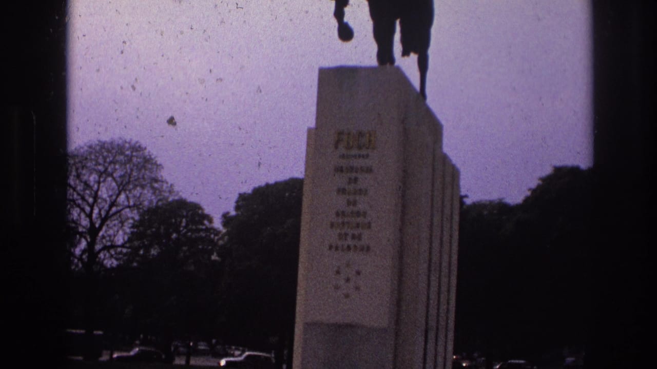 Stone pedestal with horse statue above, trees and parked cars visible in the background.