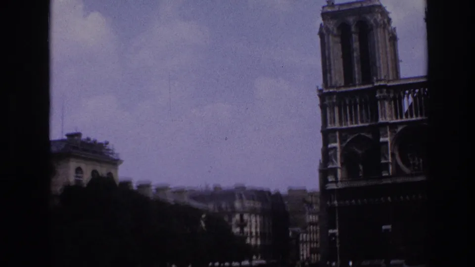 1967 Paris view toward Notre-Dame Cathedral, with rooftops and sky visible in soft 8mm color footage.