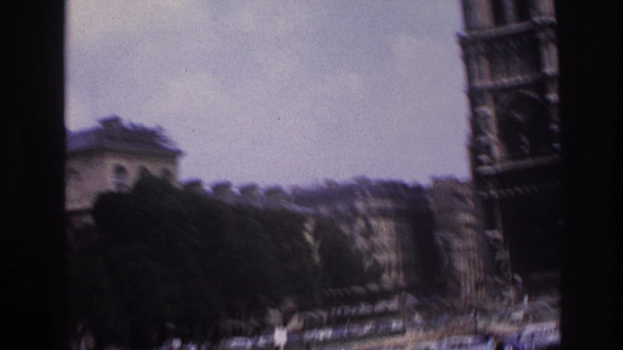 Notre-Dame and nearby Paris buildings seen through a dark vertical window edge.