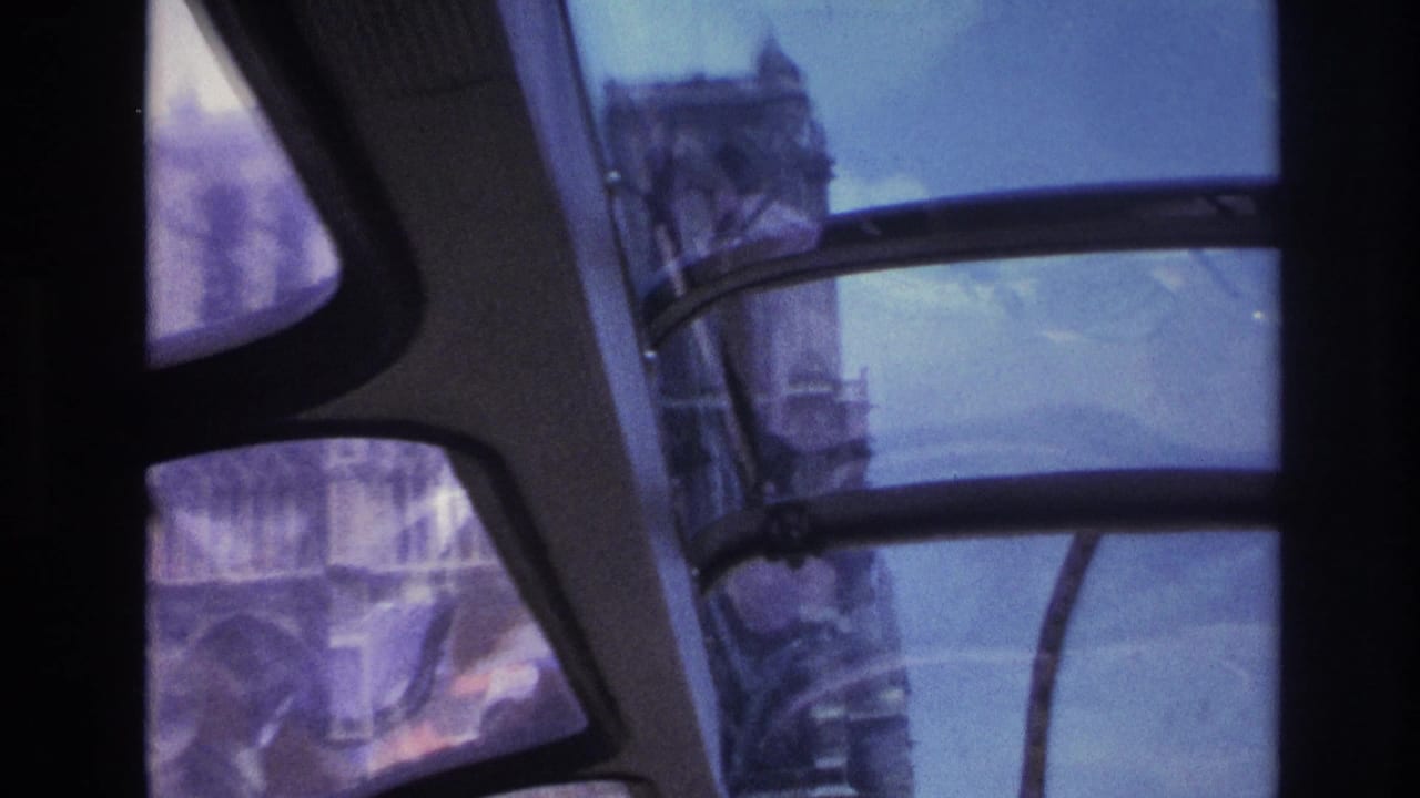 1967 Paris view through curved tour-bus windows, with blurred buildings and tinted glass dominating the frame.