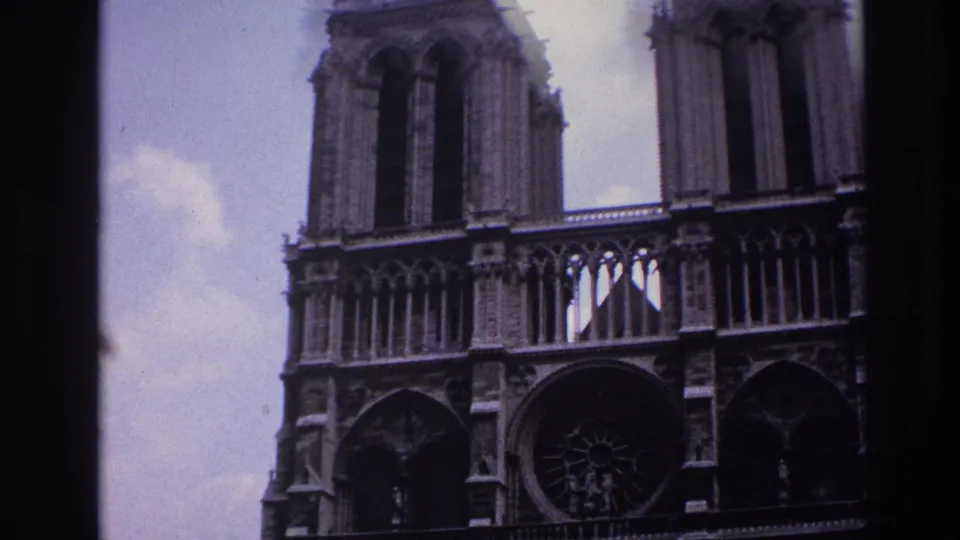 Notre-Dame Cathedral facade in Paris, with twin towers, Gothic arches, and the rose window visible in 1967 home-movie footage.