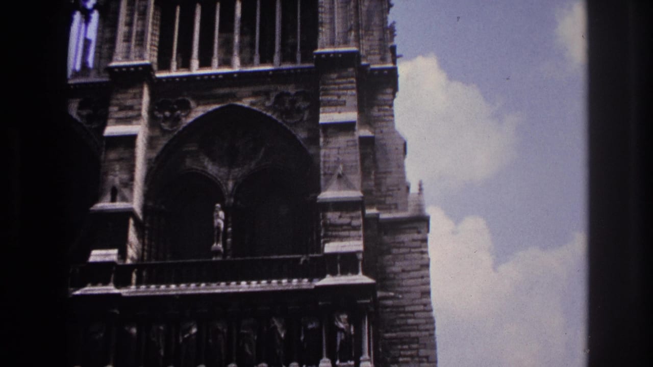 Upper cathedral facade with a large arch, stone columns, and cloudy sky.