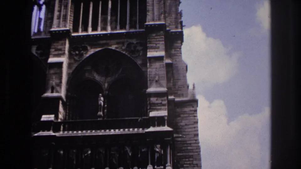 1967 Paris frame with an upper section of a Gothic cathedral, including a tall arch, vertical masonry, carved details, and sky behind it.