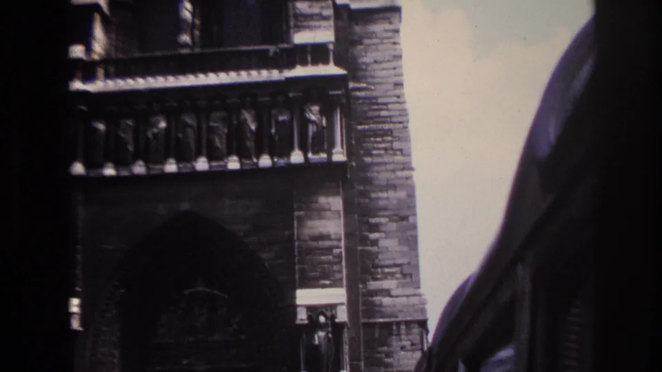 1967 Paris frame showing Gothic stone architecture with stacked arches, carved details, and dark foreground edges partly obscuring the view.