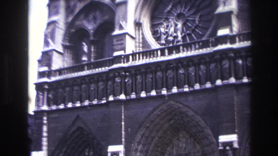 1967 Paris frame with Notre-Dame's rose window, balcony rail and pointed stone arches visible.