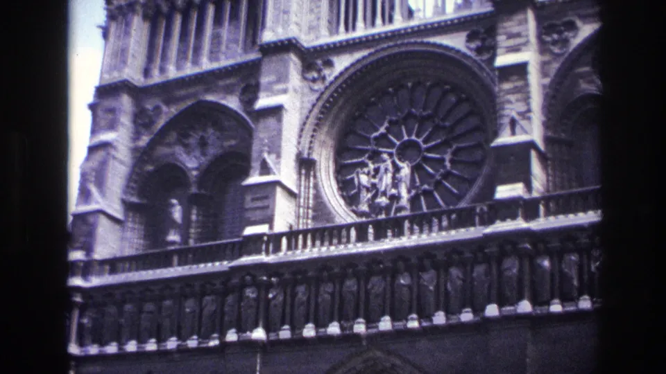 Visitor-shot 1967 Paris view of Notre-Dame's rose window, arcade and balcony rail in soft 8mm color.