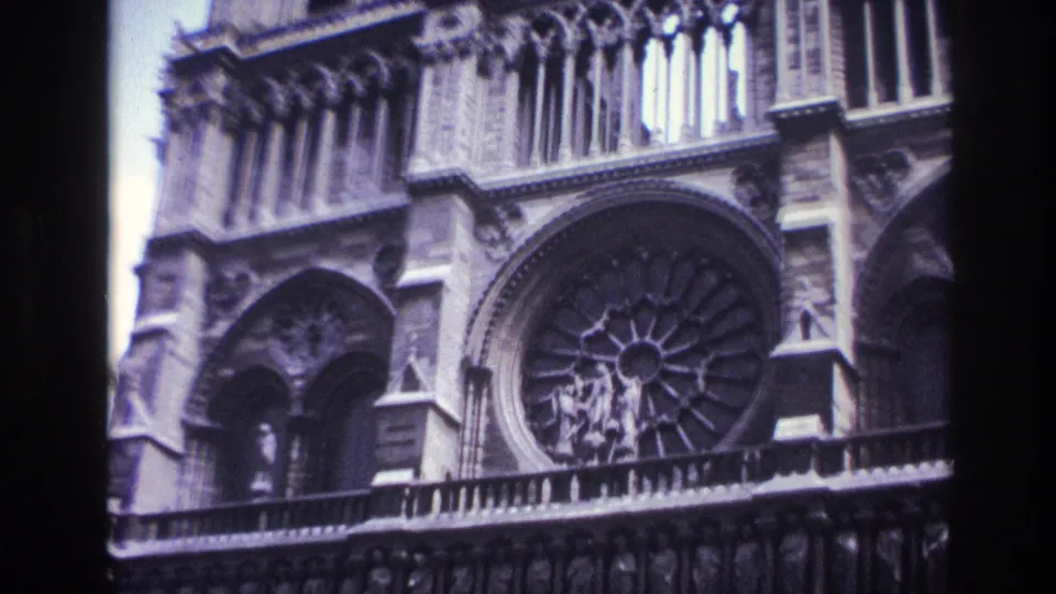 1967 Paris home-movie still showing Notre-Dame rose window, adjacent arch and upper facade masonry.