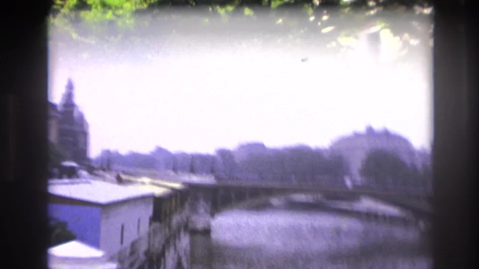 Soft, bright 1967 Paris river view with a bridge, embankment walls, riverside trees, and distant architecture.
