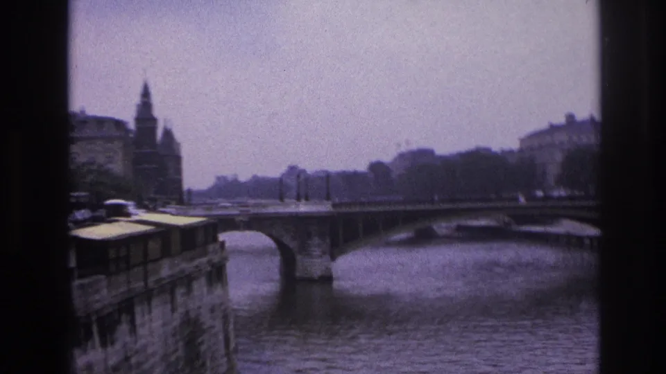 1967 Paris river scene showing a stone bridge, water, embankments, and historic buildings along the banks.