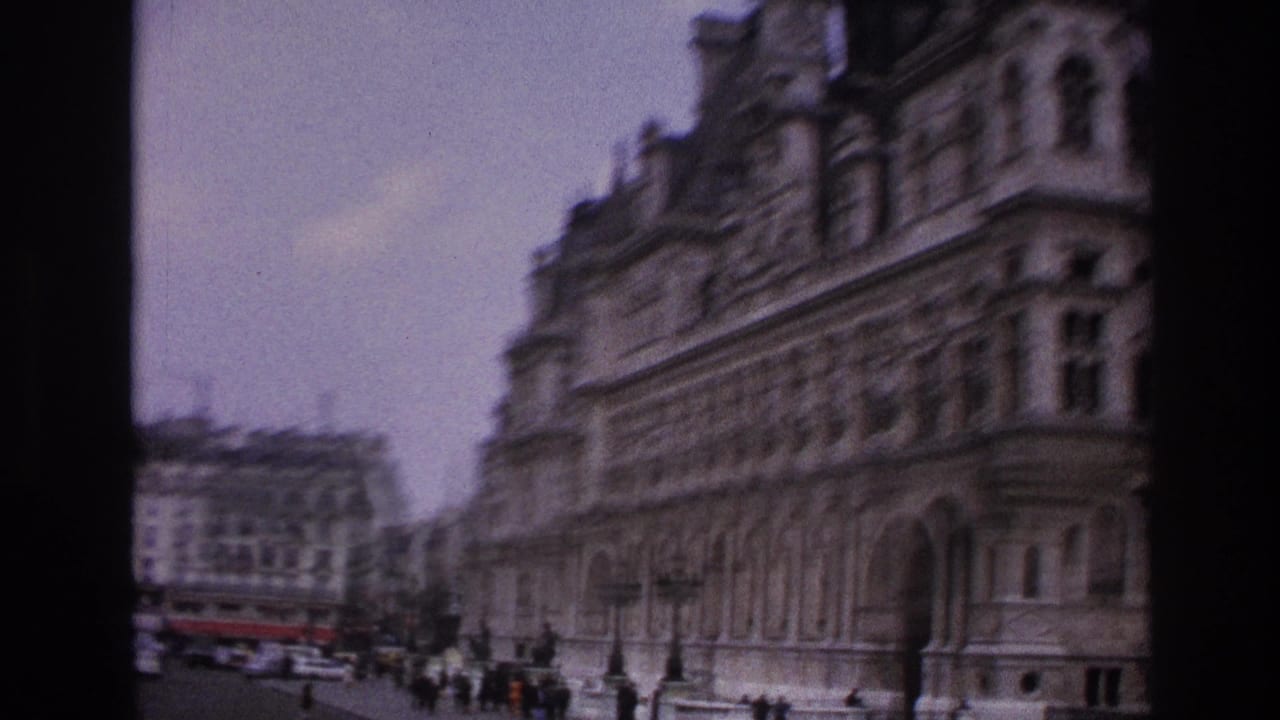 Large ornate stone facade along a Paris street with people and vehicles below.