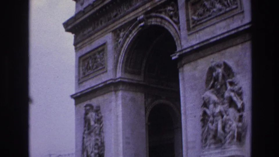 Close 1967 Paris view of the Arc de Triomphe from below, emphasizing the arch, carved stone reliefs, and handheld 8mm softness.