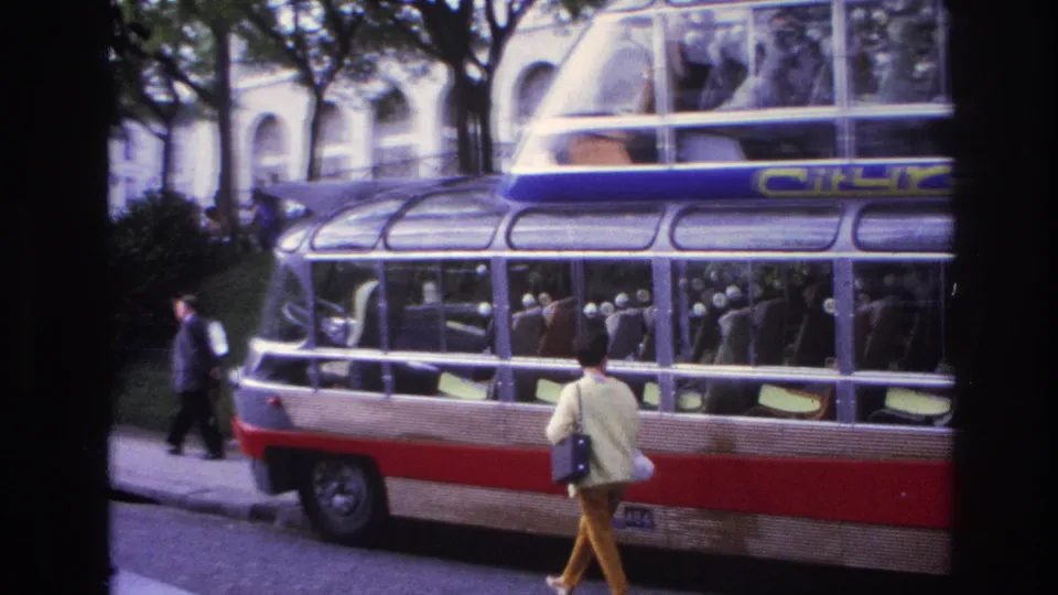 1967 Paris street view with a Citirama double-decker tour bus, a woman in yellow walking near the curb, and another pedestrian in dark clothing.