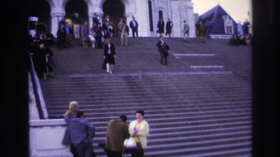 Wide 1967 Paris staircase frame with scattered pedestrians, arched building openings, and people gathered near the lower steps.