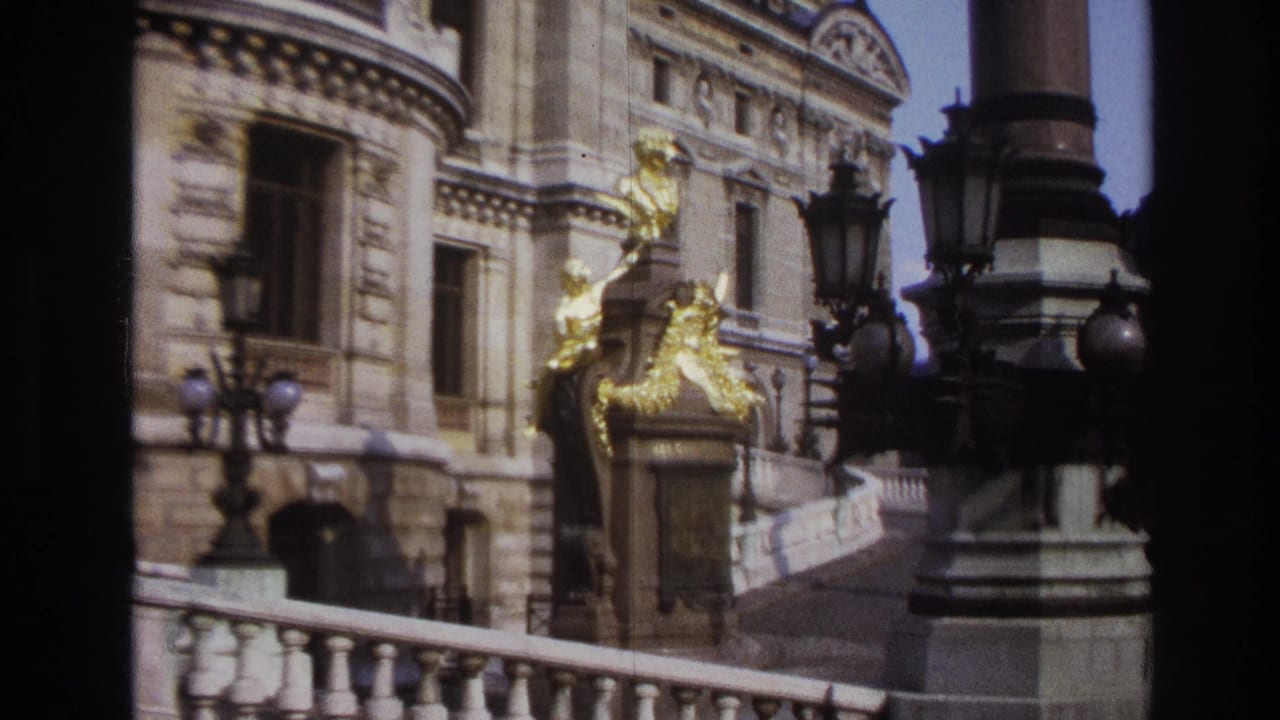 Gilded sculptural entrance detail beside stone windows and dark lamps.