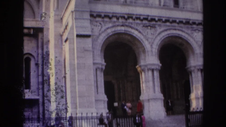 1967 Paris exterior showing ornate stone arches and columns with visitors near the steps and wrought iron fencing.