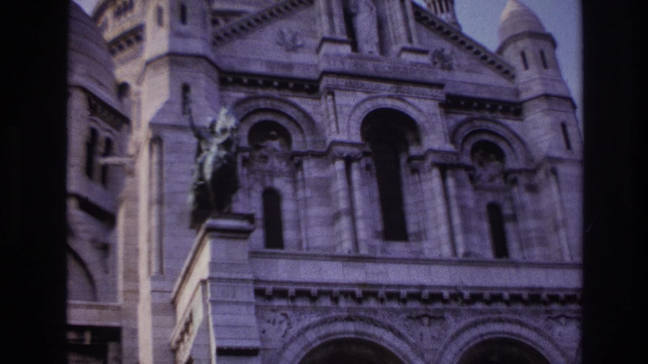 1967 Paris frame of Sacre-Coeur facade details, with arched openings and a dark vertical edge from the film scan.