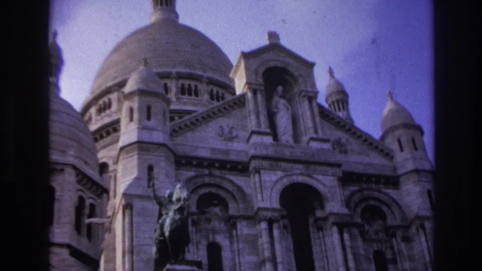 1967 Paris frame of Sacre-Coeur with its main dome, smaller domes, sculpted facade, and bronze statue under a pale sky.