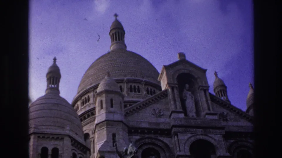 1967 Paris frame of Sacre-Coeur Basilica, showing the domed roofline, stone carving, and statue above the main entrance.