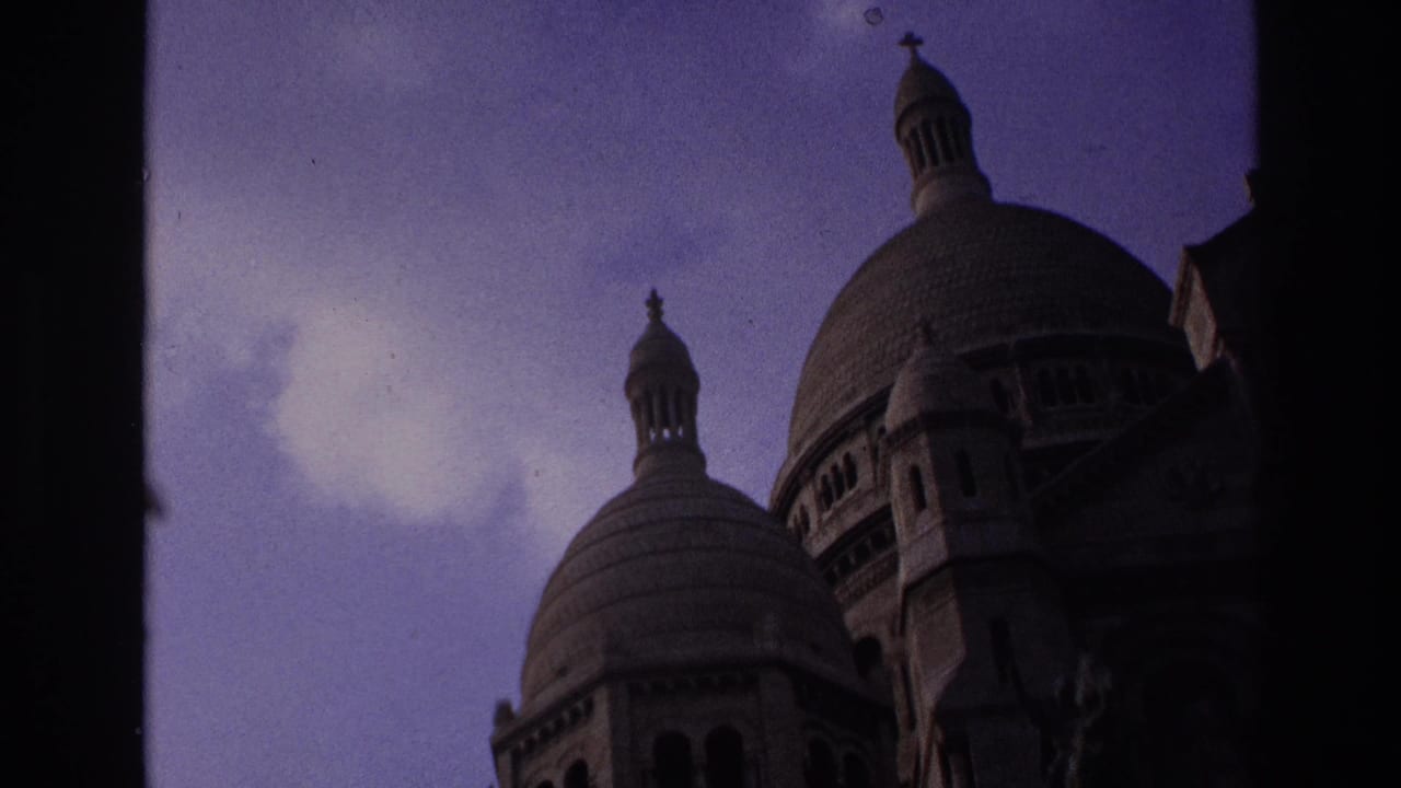 Sacre-Coeur domes and cupolas viewed from below against a purple sky.
