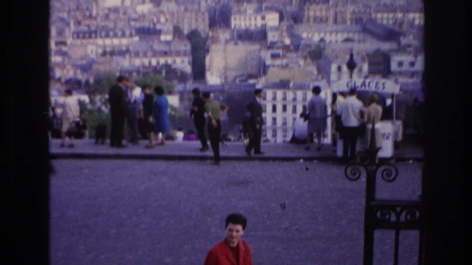 A Paris overlook scene shows visitors near railings, a GLACES sign, and a hazy cityscape in the background.