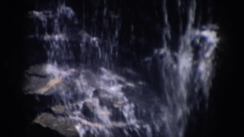 1959 Colorado 8mm frame of water cascading across stepped dark rocks in a close natural view.