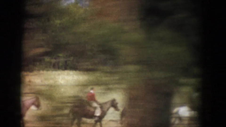 Soft, motion-blurred 1959 Colorado home-movie frame showing horseback riders moving through a grassy field near trees.