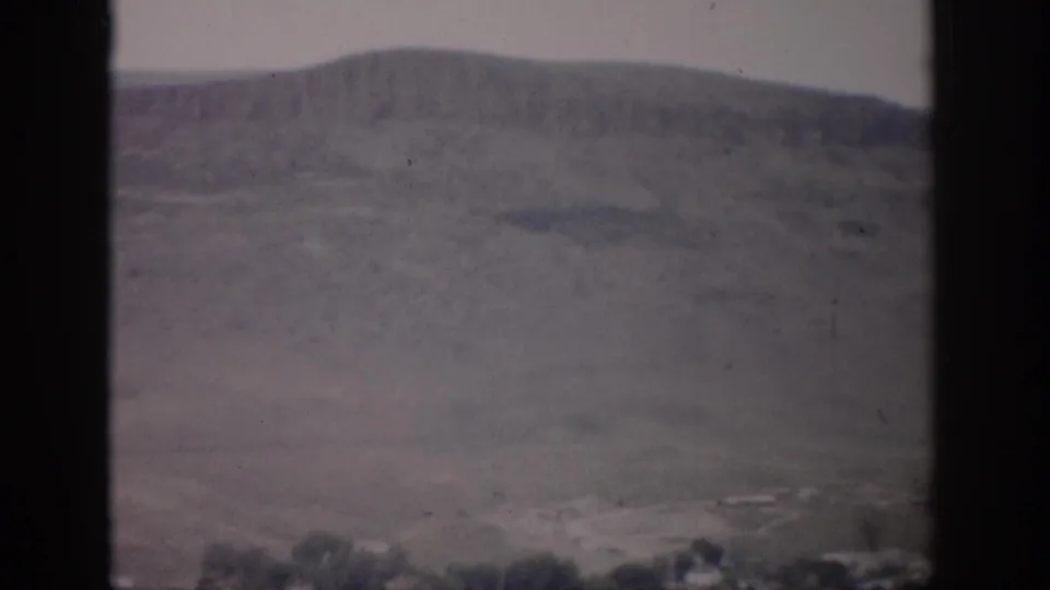 Final frame of the 1959 Colorado clip with open farmland, low hills, pale sky, and a passenger-window view.