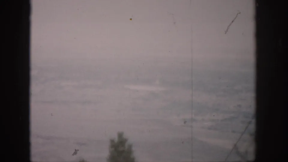 Pale 1959 Colorado landscape seen through window divisions, with faint trees at the lower edge.