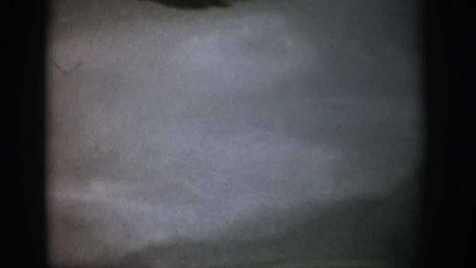 1959 Colorado 8mm frame showing a hazy underwater streambed, muted gravel tones, and heavy dark frame edges.