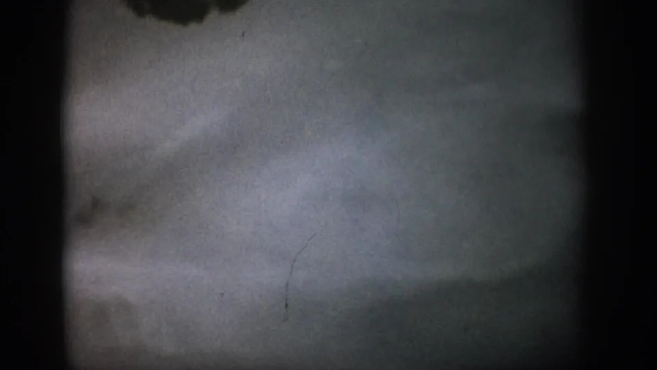 1959 Colorado 8mm frame with a blurred underwater streambed, pale water haze, film grain, and dark gate edges.
