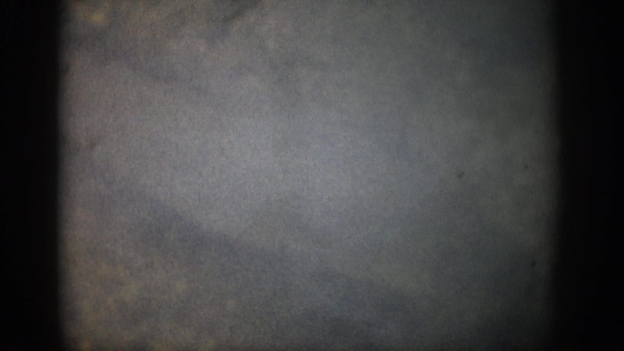 1959 Colorado 8mm frame with murky underwater blue-gray tones, dark borders, grain, and indistinct mottled forms.