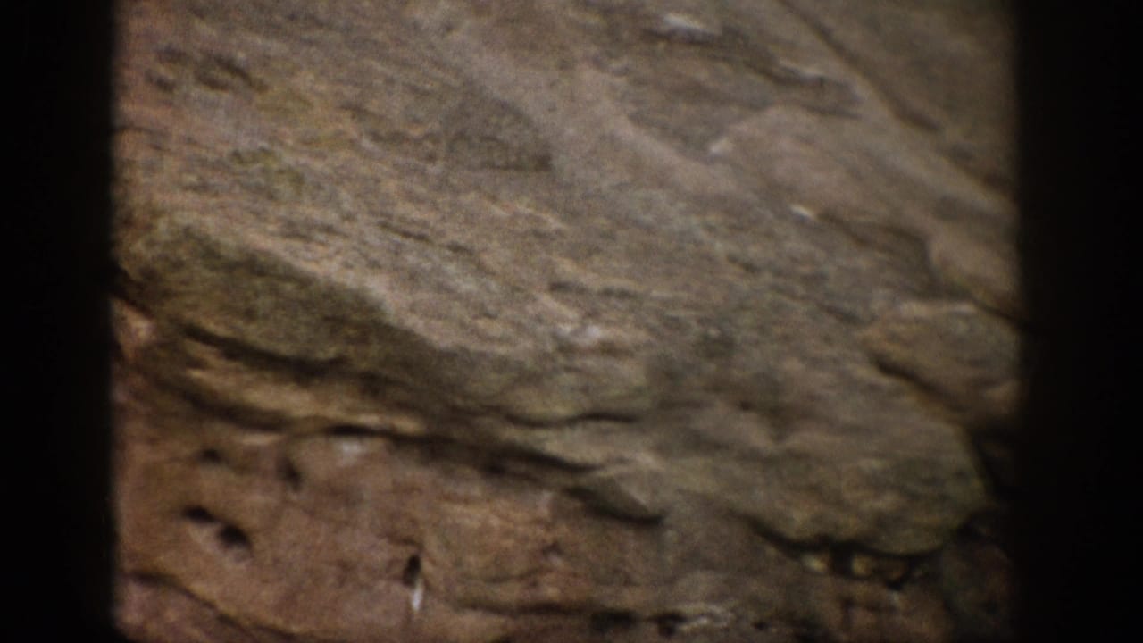 1959 Colorado 8mm frame with weathered rock layers, muted earth tones, and visible film-frame edges.
