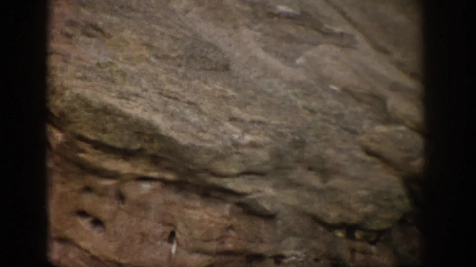 1959 Colorado 8mm frame with weathered rock layers, muted earth tones, and visible film-frame edges.