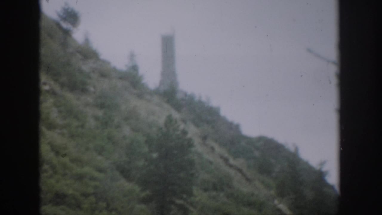 1959 Colorado 8mm view of a soft, misty hillside with a distant tower framed by dark vertical window edges.