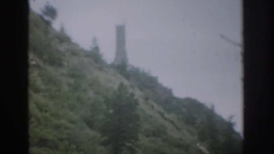 1959 Colorado 8mm view of a soft, misty hillside with a distant tower framed by dark vertical window edges.