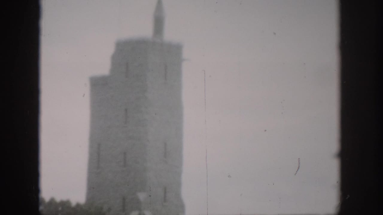 1959 Colorado 8mm frame showing a soft, hazy view of a stone tower with a dark window edge in the foreground.