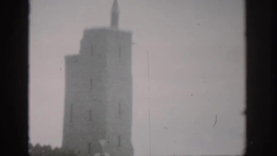 1959 Colorado 8mm frame showing a soft, hazy view of a stone tower with a dark window edge in the foreground.