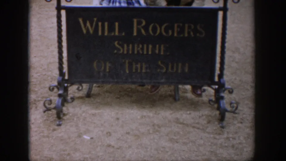 1959 Colorado 8mm frame showing the Will Rogers Shrine of the Sun sign with gold lettering and iron supports.