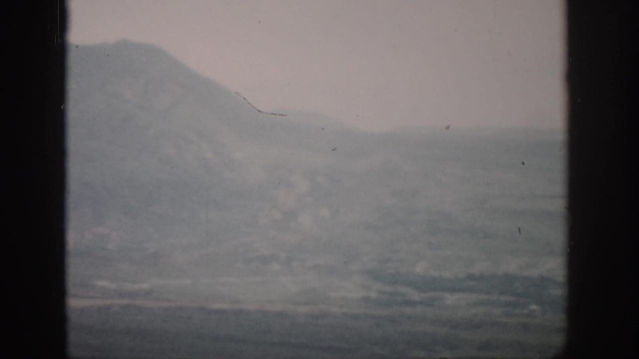 Distant mountains and haze behind a central dark window divider.