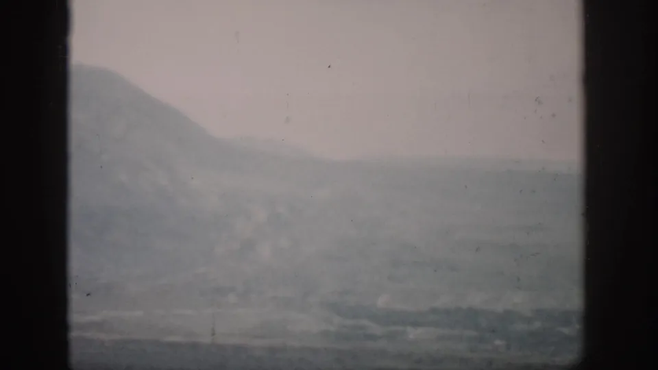 A faded 1959 Colorado landscape frame with hazy mountains, muted terrain, and dark window edges.