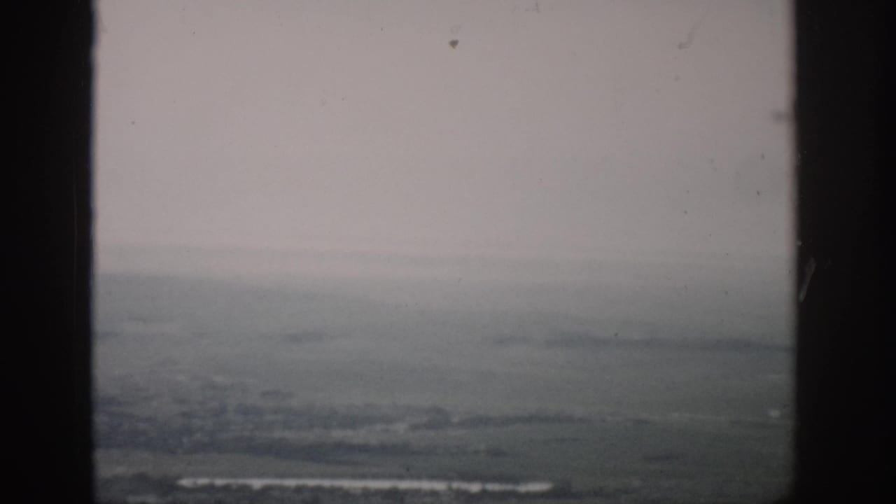 1959 Colorado home-movie view of hazy flat land and a faint horizon through window framing.
