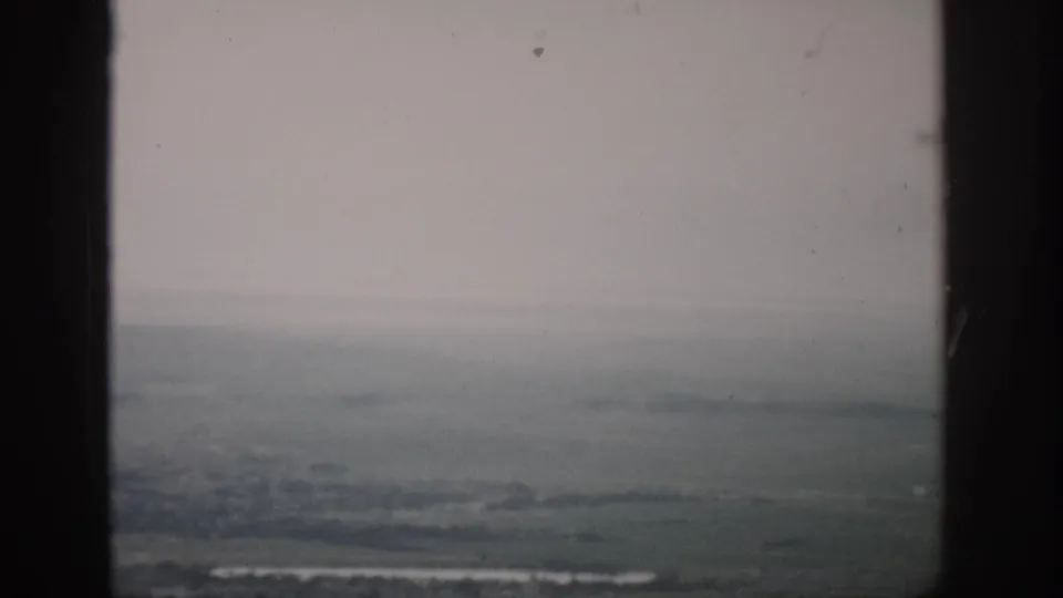 1959 Colorado home-movie view of hazy flat land and a faint horizon through window framing.