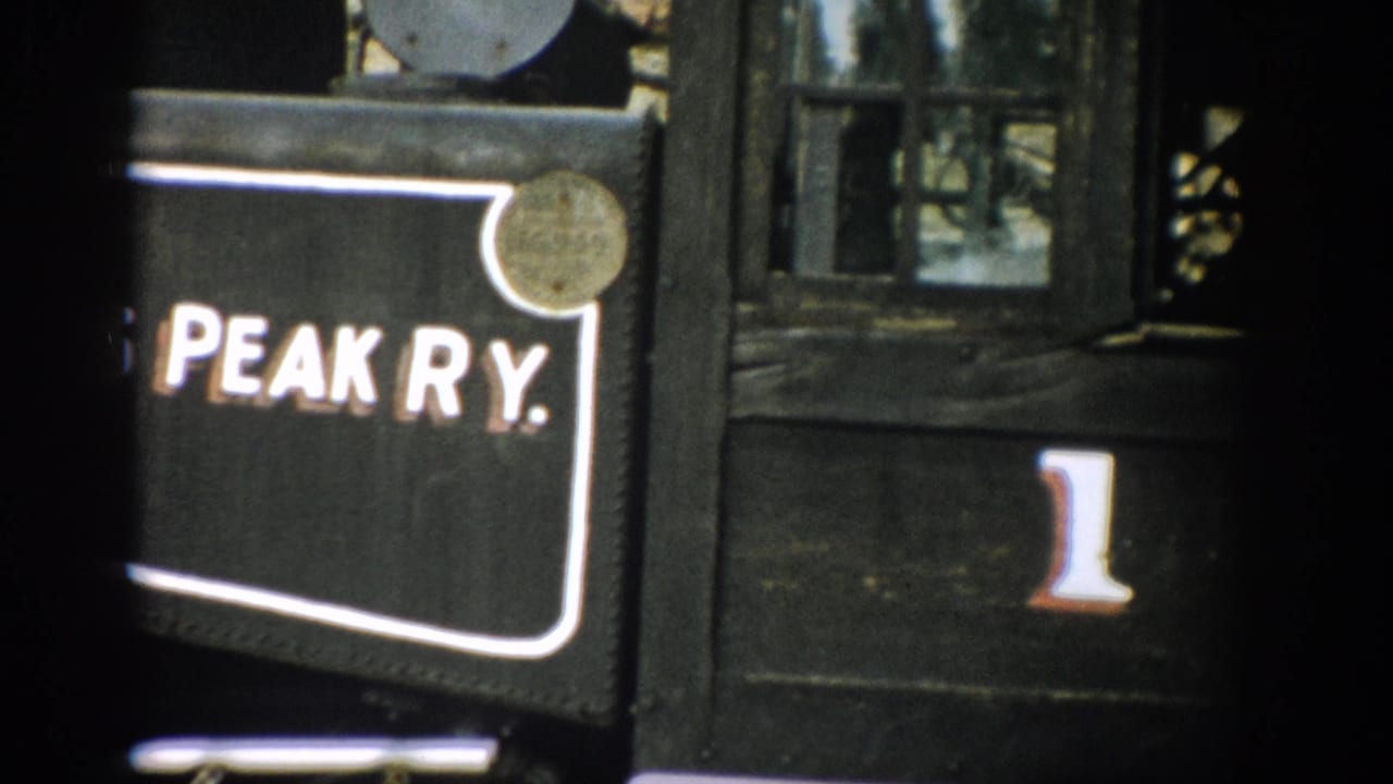 1959 Colorado 8mm frame showing a close-up of a black railway car panel marked Peak Ry. with the number 1 beside it.