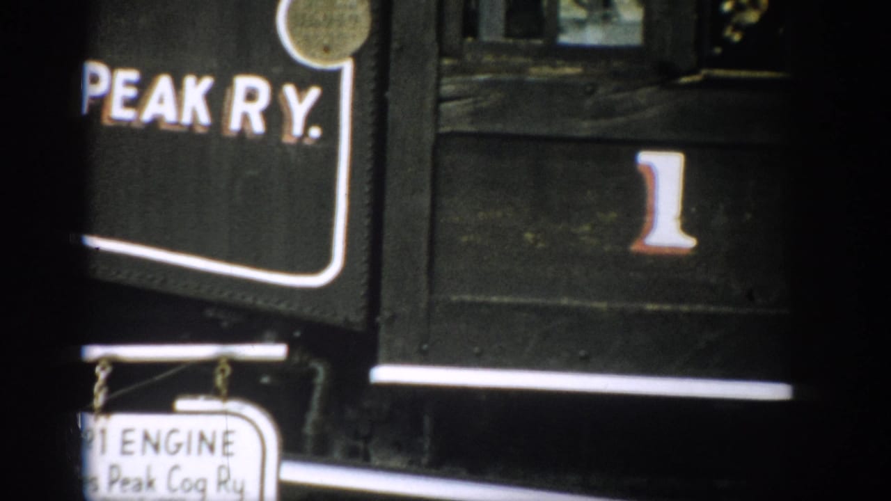 Close view of Peak Ry. lettering, the number 1, and a small hanging engine sign on a train car.