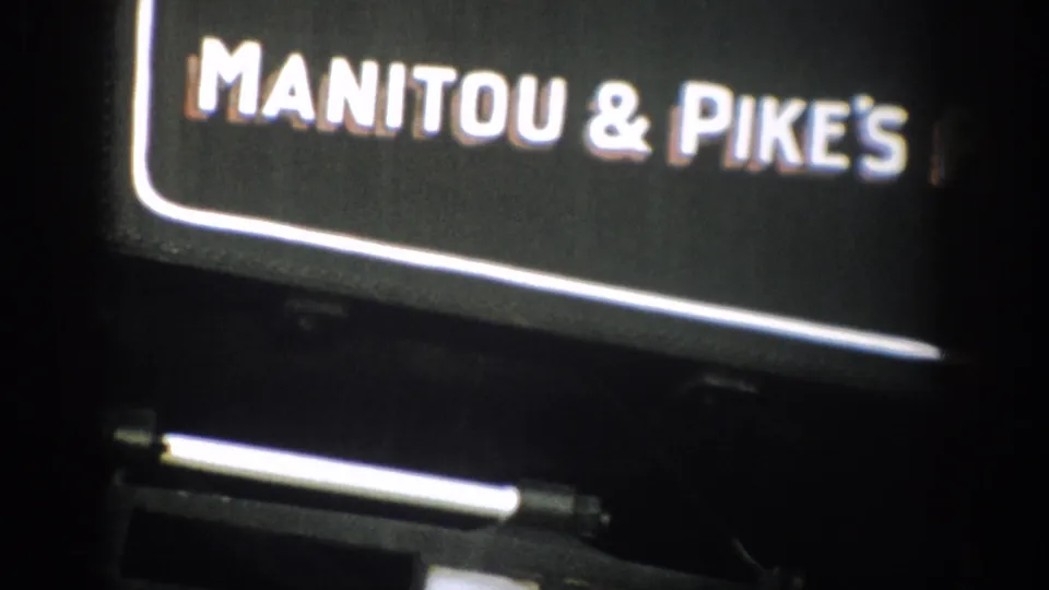 1959 Colorado frame with the Manitou & Pikes portion of the railway sign visible on a dark train car.