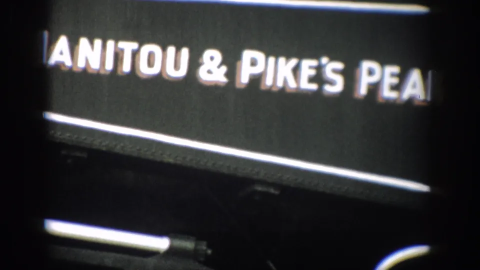 1959 Colorado 8mm close-up of white Manitou & Pike's Peak railway lettering on a black train side panel.