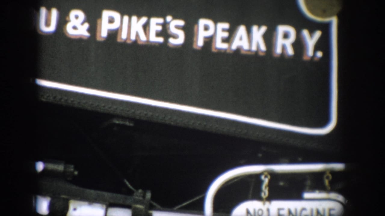 Close view of Manitou & Pike's Peak Ry. lettering on a black engine, with part of the No.1 Engine plate visible below.