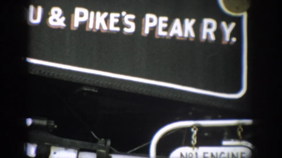 Close view of Manitou & Pike's Peak Ry. lettering on a black engine, with part of the No.1 Engine plate visible below.